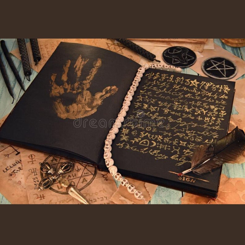 Pode incluir: Um livro preto aberto com letras douradas e uma impress&atilde;o de m&atilde;o dourada na capa. O livro &eacute; cercado por velas, um pentagrama e uma pena de pena. O livro tem a palavra "SIGN" escrita no canto inferior direito.