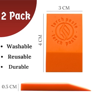 May include: Two orange plastic scraper tools, each measuring 3 cm by 4 cm. The tools are shaped like a wedge and have a rounded edge. The tools are labeled "torch paste" and are designed for spreading and smoothing paste.