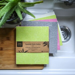 May include: A set of four Swedish dish cloths in green, gray, pink, and white. The cloths are made from biodegradable, compostable, and plastic-free materials. The packaging is made from recycled paper and is compostable. The cloths are 17 x 20 inches.