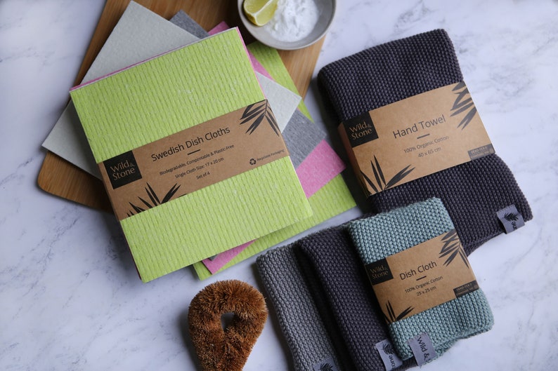 May include: A set of four green Swedish dish cloths, two gray hand towels, and a green dish cloth. The cloths are made of 100% organic cotton and are biodegradable, compostable, and plastic-free. The towels are 40 x 65 cm and the cloths are 24 x 24 cm.