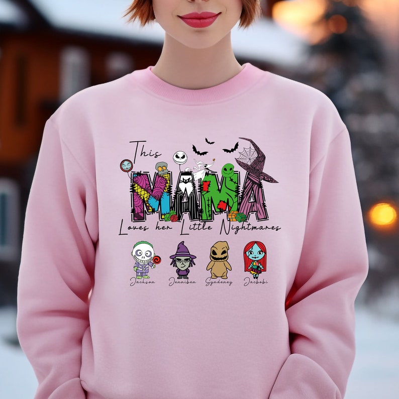 May include: Pink sweatshirt with a graphic of the word "MAMA" in a patchwork style with characters from the movie "The Nightmare Before Christmas". The text "This Mama Loves Her Little Nightmares" is printed below the graphic. The names "Jackson,  Jannifer, Sydney, Jacob" are printed below the characters.