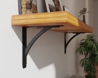 May include: Black metal shelf brackets with a curved design, supporting a wooden shelf with two framed pictures on top.