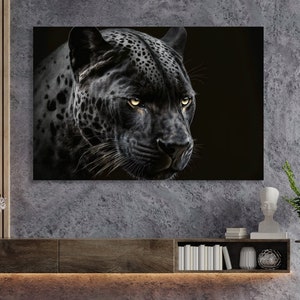 May include: A canvas print featuring a close-up of a black jaguar's face. The jaguar has yellow eyes and a black coat with dark spots. The artwork is displayed on a wall above a wooden cabinet.