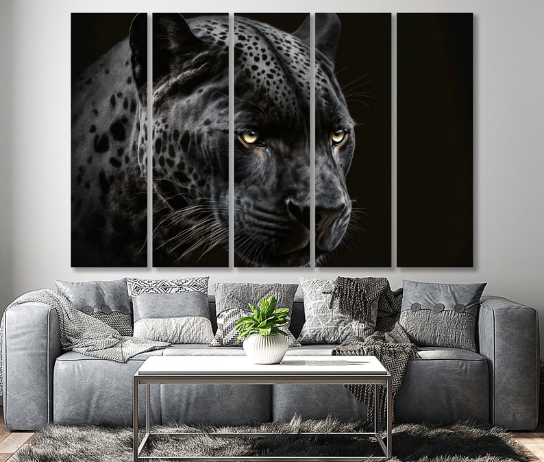 May include: A multi-panel canvas art piece featuring a close-up of a black jaguar with yellow eyes. The jaguar's fur is detailed with spots, and the artwork is set against a dark background. The artwork is displayed above a gray sofa.