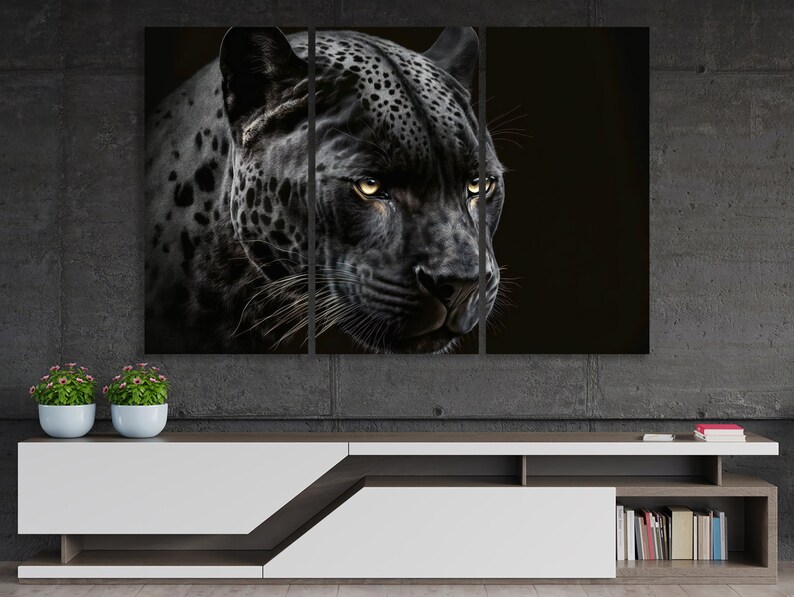 May include: A triptych canvas print featuring a close-up of a black jaguar's face. The jaguar's fur is a dark gray with black spots, and its eyes are a bright yellow. The background is a solid black, creating a dramatic contrast.