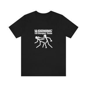 Może przedstawiać: Czarny T-shirt z białym nadrukiem przedstawiającym dwie postaci z patyków. Tekst "WARNING VR Danger Zone" znajduje się nad nadrukiem.