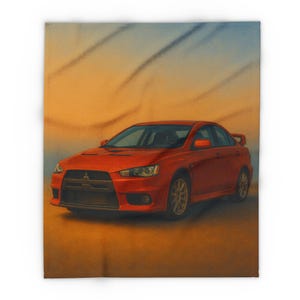 Op de afbeelding: Een rode Mitsubishi Lancer Evolution auto is afgebeeld op een deken. De auto is het middelpunt, tegen een gradiënt achtergrond van oranje en blauwe tinten. Het ontwerp van de deken toont de strakke lijnen en sportieve uitstraling van de auto.