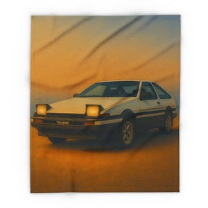 Op de afbeelding: Een witte en zwarte auto met het woord "TRUENO" op de voorkant, tegen een oranje en blauwe gradiënt achtergrond. De koplampen van de auto zijn aan en de afbeelding heeft een vintage of retro uitstraling.