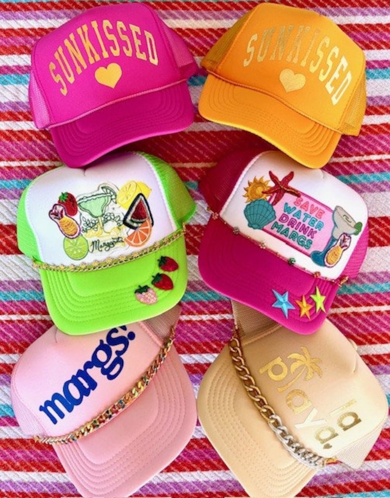 May include: Six colorful trucker hats with various designs and embellishments. The hats feature a variety of themes, including summer, beach, and cocktails. The hats are all made of a mesh material and have a curved brim.