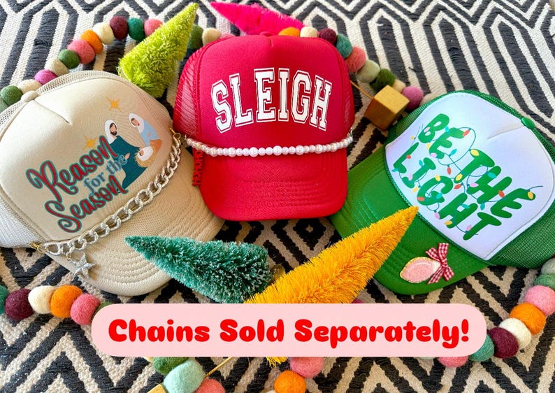 May include: Three Christmas themed trucker hats. The first hat is beige with a white design that says "Reason for the Season" and a silver chain. The second hat is red with a white design that says "SLEIGH". The third hat is green with a white design that says "Be the Light" with a string of white lights. The text "Chains Sold Separately!" is at the bottom of the image.
