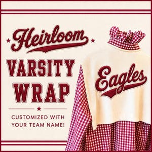 May include: A cream-colored knit sweater vest featuring the word Eagles in dark red embroidery on the back, layered over a red and white gingham button-down shirt. The text Heirloom Varsity Wrap Customized With Your Team Name is visible.