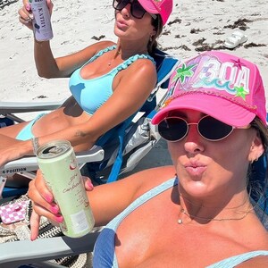 Op de afbeelding: Twee vrouwen in blauwe en witte bikini's en roze baseballpetten met "30A" erop geborduurd. Een vrouw houdt een blikje bruisend water vast en de andere een blikje koolwaterstofvrij kokoswater.