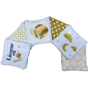 Puede incluir: Seis almohadillas de algod&oacute;n blanco para desmaquillar con diferentes dise&ntilde;os bordados en dorado. Los dise&ntilde;os incluyen una hoja de palma dorada, lunares dorados, una luna y estrellas doradas, y el texto "Licorne en Or".