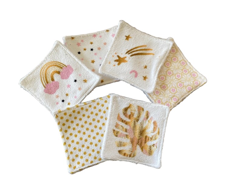 Puede incluir: Conjunto de seis almohadillas de algod&oacute;n blanco para desmaquillar con diferentes dise&ntilde;os dorados y rosados. Los dise&ntilde;os incluyen un arco&iacute;ris, estrellas, una estrella fugaz, una hoja y un patr&oacute;n geom&eacute;trico.