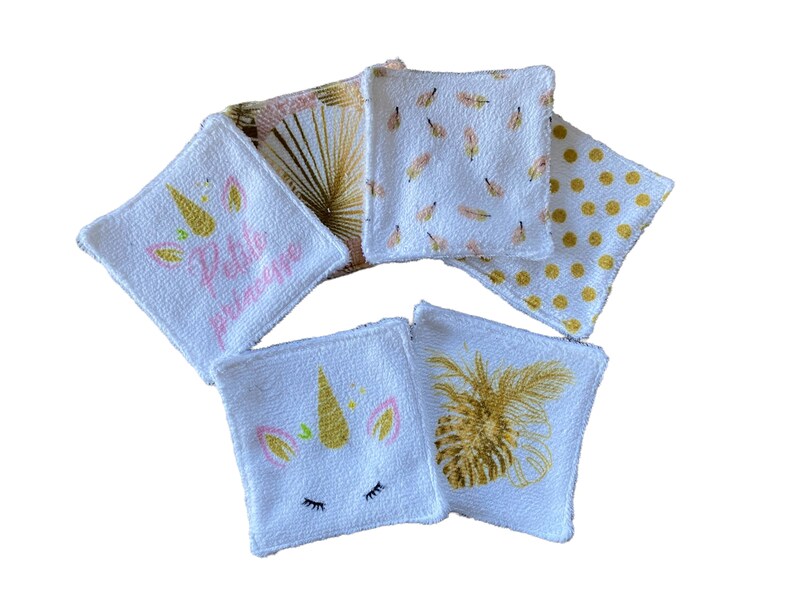 Puede incluir: Conjunto de seis almohadillas desmaquillantes de algod&oacute;n blanco con diferentes dise&ntilde;os. Los dise&ntilde;os incluyen un unicornio con el texto "Petite Princesse", una pi&ntilde;a y un patr&oacute;n de plumas doradas.
