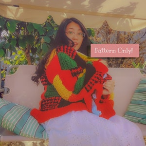 May include: A person wearing a colorful crochet cardigan with a multi-colored pattern. The cardigan is made of different colored yarn, including red, yellow, green, and black. The person is sitting on a bench with a white skirt and a striped cushion. The text "Pattern Only!" is visible in the image.