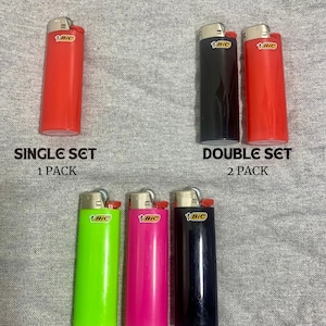 May include: Image of BIC lighters in various colors, including red, black, green, and pink. The image displays a single lighter, a double set, and a triple set, with text indicating the number of lighters in each bundle. The lighters are on a gray background.