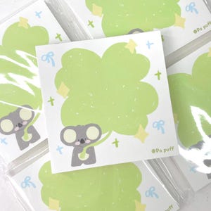 以下が含まれることがあります： 緑の木と星が描かれたコアラのイラストステッカー4枚セット。ステッカーは白地に、"@Po puff"の文字が書かれています。