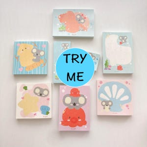 以下が含まれることがあります： かわいいコアラのイラストが描かれた、カラフルな付箋6枚セット。それぞれの付箋は、さまざまなポーズと設定でコアラが描かれた、異なるデザインになっています。これらの付箋は、プランナー、ジャーナル、デスクに遊び心を加えるのに最適です。