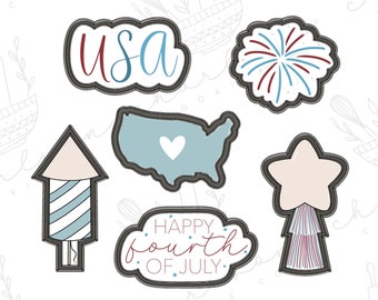 May include: Set of six cookie cutters in black with a white outline. The cutters are shaped like a firework, a star, a rocket, a map of the United States, a banner that says "Happy Fourth of July", and a banner that says "USA".
