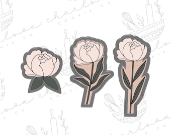 May include: Three cookie cutters in the shape of peonies. The cutters are made of metal and have a gray finish. The peonies are outlined in black and have a pink fill.