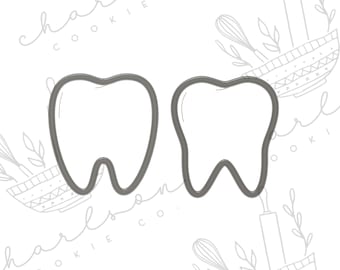 May include: Two gray metal cookie cutters shaped like teeth.