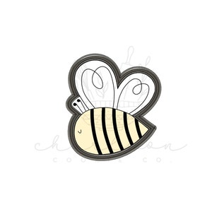 May include: A black and yellow bee cookie cutter with a heart-shaped wing design.