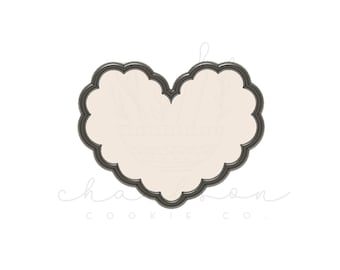 May include: A metal cookie cutter in the shape of a heart with a scalloped edge.