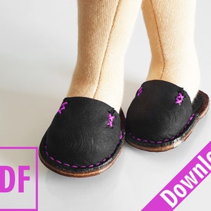 May include: A pair of black leather doll shoes with pink stitching. The shoes have a rounded toe and a simple design.