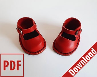 May include: A pair of red leather doll shoes with a strap and buckle. The shoes are on a white background. PDF Download.