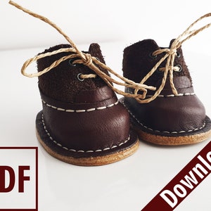 May include: A pair of brown leather boots with tan laces. The boots have a white stitching detail around the sole. The boots are tied together with the laces.