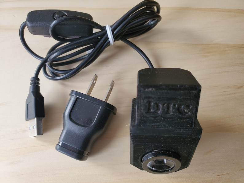 Puede incluir: Una luz LED negra alimentada por USB con un adaptador de corriente y un interruptor de encendido/apagado. La luz tiene una lente transparente y la palabra "DIYC" est&aacute; impresa en el lateral.