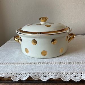 May include: White ceramic casserole dish with a gold lid and gold polka dots.