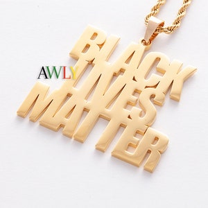 Könnte beinhalten: Goldkette mit einem Anhänger, auf dem in fetten Blockbuchstaben "Black Lives Matter" steht.