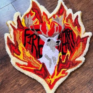 May include: A red, yellow, and white rug with a deer in the center and the words "Fire Heart" around it.