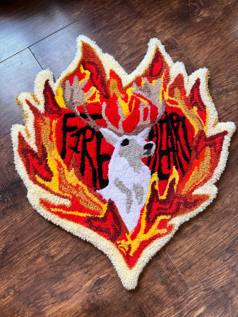 May include: A red, yellow, and white rug with a deer in the center and the words "Fire Heart" around it.