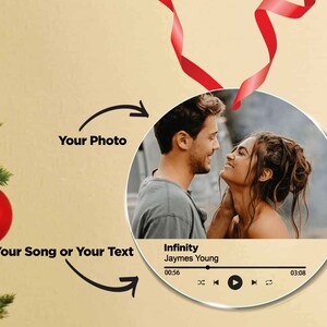 Peut inclure: Une boule ronde et transparente avec une photo de couple au centre. La boule a un design de lecteur de musique avec la chanson "Infinity" de Jaymes Young en lecture.