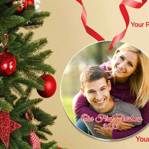Peut inclure: Une boule de No&euml;l ronde et blanche avec une photo d'un couple. La boule est orn&eacute;e du texte "Our First Christmas 2023" en &eacute;criture cursive rouge.