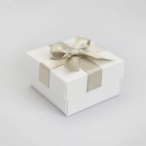White wedding favour box with hint of green ribbon.