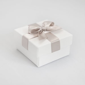 White wedding favour box with taupe ribbon.