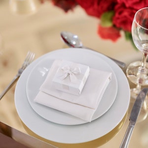 White wedding favour box with ivory ribbon with table decor.