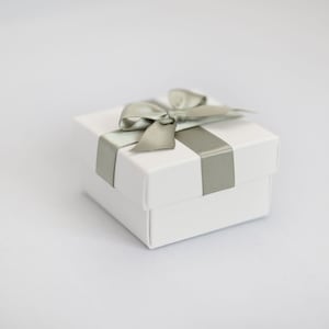 White wedding favour box with sage green ribbon.