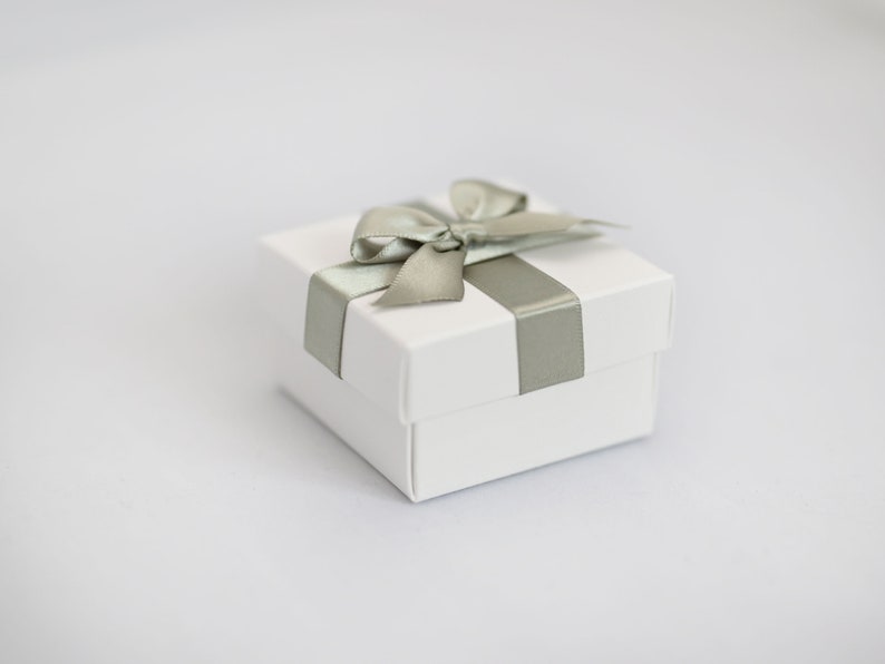 White wedding favour box with sage green ribbon.