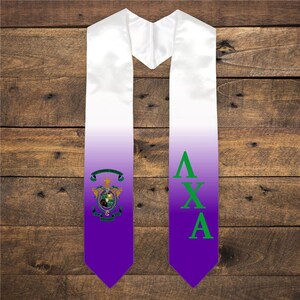 May include: White and purple graduation stole with a green and gold crest and the letters "AXA" in green.