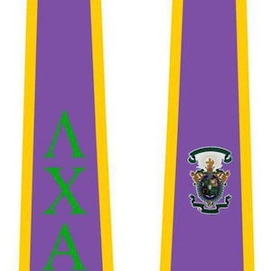 May include: Purple graduation stole with gold trim and green lettering that reads "Delta Sigma Theta". The stole also features a green and gold crest.