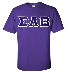 May include: A purple t-shirt with the Greek letters ΣΛB in a dark purple and white design. The short-sleeved shirt is made of a soft material and is suitable for casual wear.