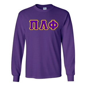 May include: Purple long-sleeve t-shirt with the letters "ΠΛΦ" in yellow outlined in purple.