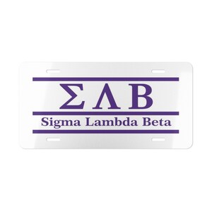 May include: A rectangular white license plate featuring purple horizontal stripes and the Greek letters Sigma Lambda Beta in purple. The text Sigma Lambda Beta is printed in purple below the Greek letters. Four mounting slots are visible.