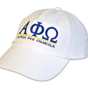 May include: White baseball cap with a curved brim. The cap features the Greek letters Alpha, Phi, and Omega in blue, with the words "ALPHA PHI OMEGA" in blue and yellow.