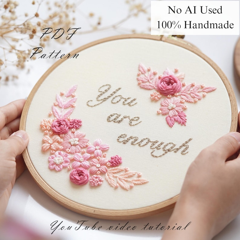 May include: Hand-embroidered hoop art with the phrase "You are enough" in cursive script. The design features pink and peach floral embroidery. The text "PDF Pattern" and "You Tube video tutorial" are also visible.